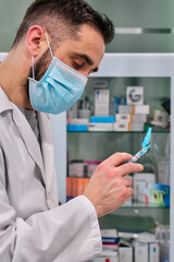 man in white coat manipulating vaccine syringe