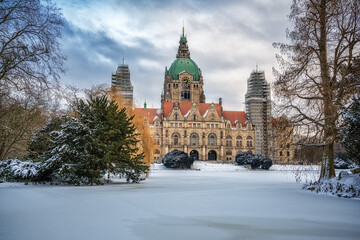 Obraz premium Neues Rathaus von Hannover im Winter mit einem schneebedeckten Maschteich und wolkigen Himmel