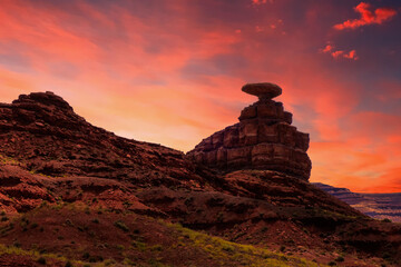Fototapeta na wymiar The Mexican Hat rock formation in Utah, USA, enjoys a beautiful sunset while it welcomes people to the small southwestern town with the same name.