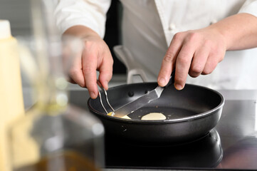 Close-up Shot, of Chef cooking in a Modern Kitchen with Lots of Ingredients Around. High quality photo