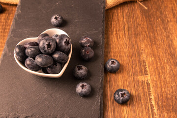 Raw organic blueberries in a heart bowl