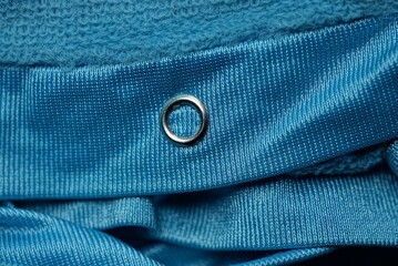 one gray small metal button rivet on blue fabric