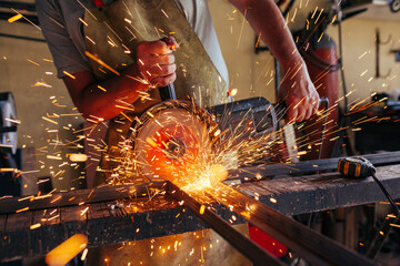 metalworker cutting steel with circular saw 