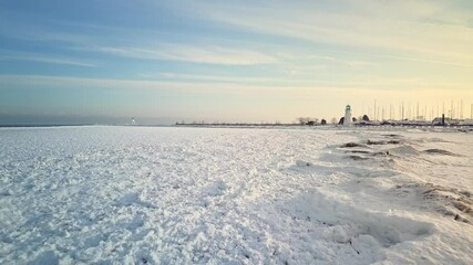Minimum altitude flight over shove ice before climbing toward a frozen marina.