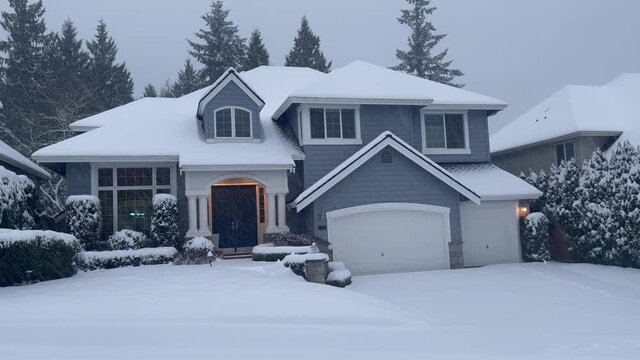 Front view of suburban home exterior during a snow storm 