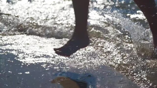 Child running throught waves in slow motion