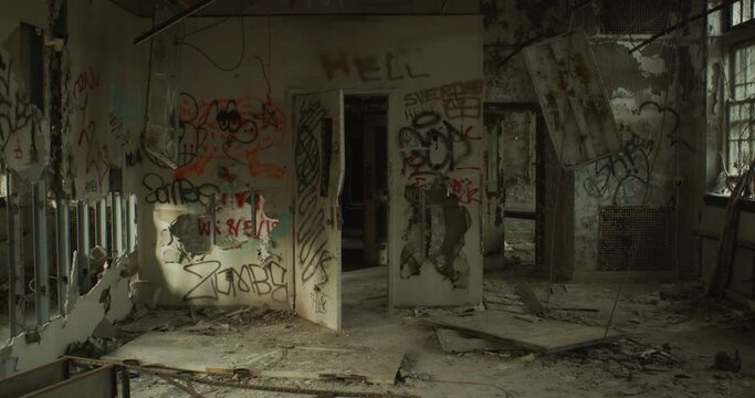 A walk through an ajar door in an eerie abandoned building, with daylight fading away as the shot moves forward