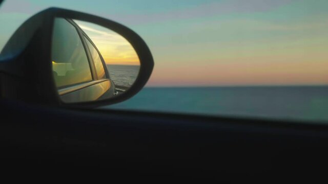 Rearview mirror, driving at sunset
