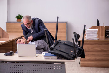Old boss and young male assistant in the office