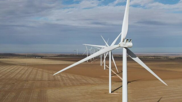 4k Aerial of large line of wind turbines in north Texas on a sunny day.