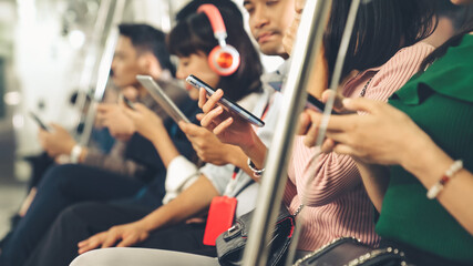 Young people using mobile phone in public underground train . Urban city lifestyle and commuting in...