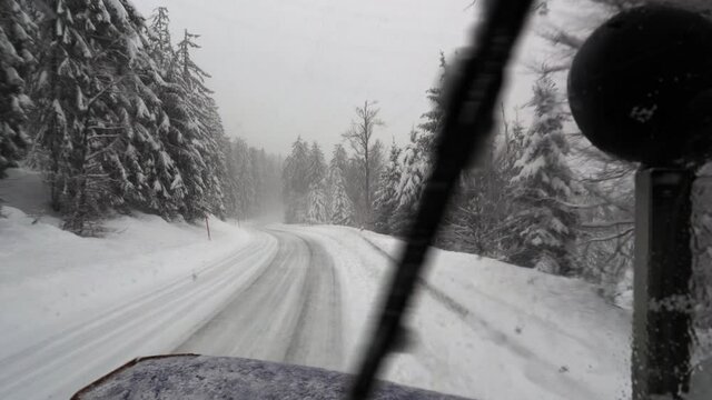 Snowplow clear snowy road. View from inside driver cab. Blackforerst, Germany