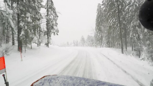 View out of drivers cab of snow plow while clear snowy road.