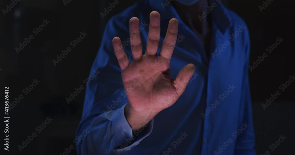 Poster midsection of caucasian man in dark room using virtual digital interface with hand outstretched