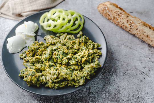 Organic Scrambled eggs with spinach in plate on marble table and bread