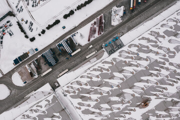 Aerial view of the trucks unloading at the logistic center. Drone photography.