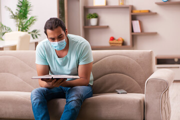 Young male student studying at home during pandemic