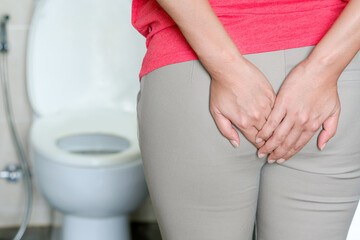 The concept of constipation. The man's hand is holding a toilet paper. Stained Toilet bathroom background