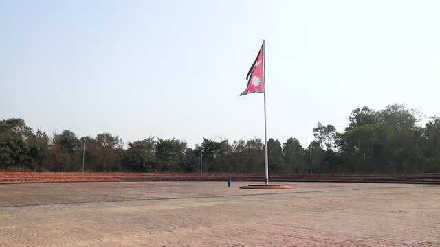 National Flag of Nepal on a tall flagpost against wind