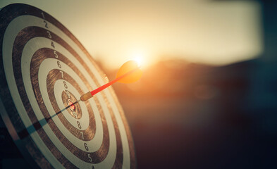 bullseye target or dart board has red dart arrow throw hitting the center of a shooting for...