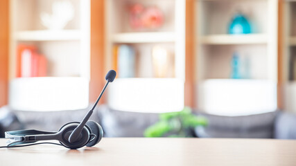 Close up soft focus on headset with telephone devices at office desk for customer service support.VOIP headset for customer service support (call center) concept.