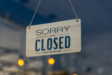 Closed sign broad through the glass of door in cafe., Sorry we're closed sign., Business service and food concept.