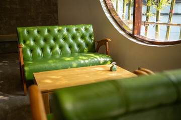 Empty Vintage green leather sofa and table in cafe restaurent, Quiet and chill cafe shop with bamboo view