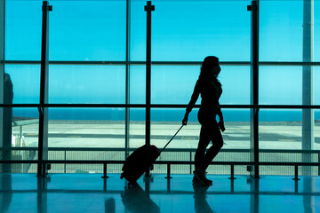 Fototapeta na wymiar woman waiting for airplane at airport terminal using smartphone