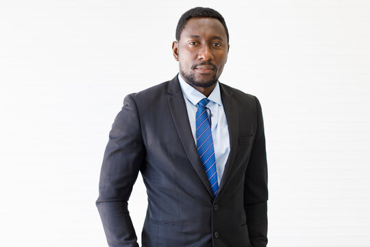 Portrait shot of smart and confident middle-aged African businessman in a neat formal black suit looking at the camera isolated with white background. Concept of successful CEO