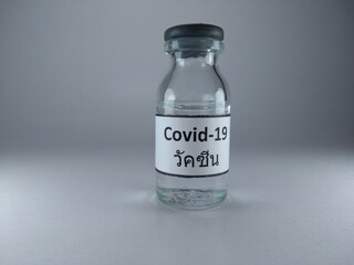 The word Covid 19 vaccine written in Thai language on a vaccine bottle 