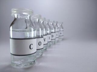 The word COVID 19 written on vaccine bottles 