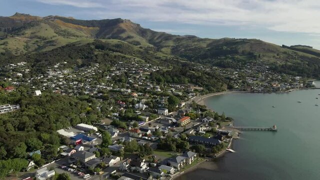 Aerial drone overview footage of Akaroa town in a sheltered bay on the Banks Peninsula, New Zealand.