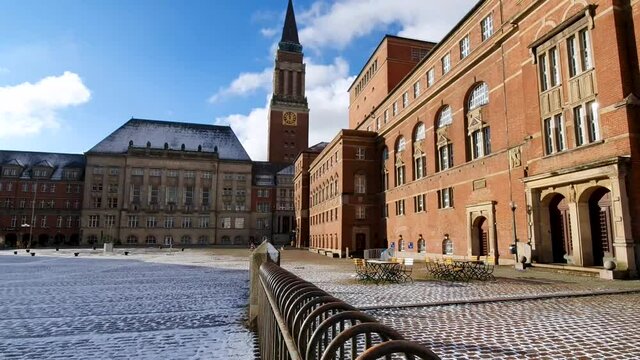 The town hall and opera house of Kiel, Germany. Winter on the Square in front of the red brick building. Slide over a fence