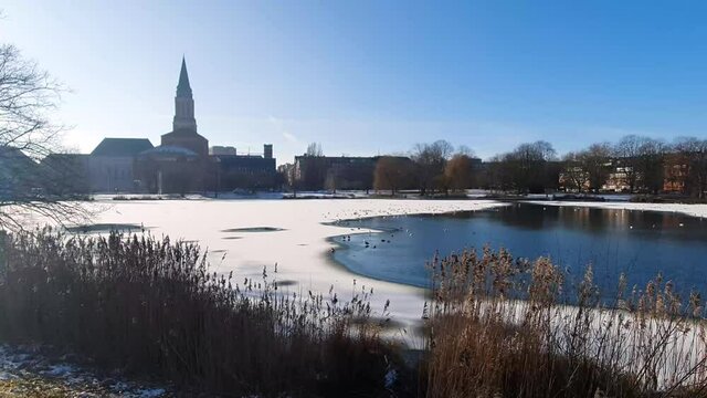 Winter in Kiel. Wide Angle shot of the lake kleiner Kiel in front of the Town Hall. Half frozen lake and blue sky