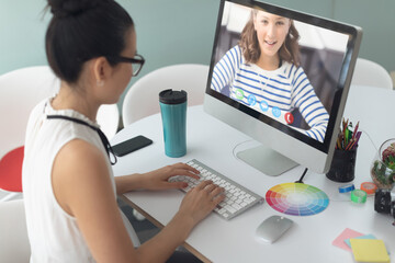 Caucasian female teacher using computer on video call with schoolgirl learning from home