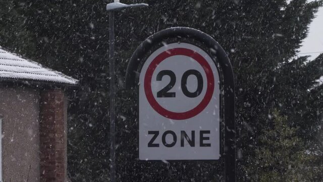 View Of 20Mph Speed Limit Warning Sign With Snow Falling. Locked Off