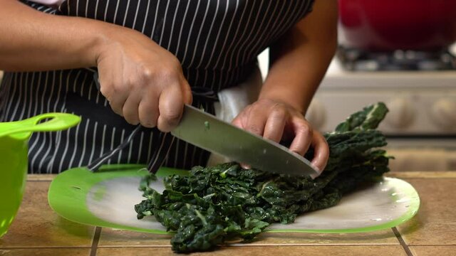 African American chef chops kale for a healthy homemade recipe - isolated 