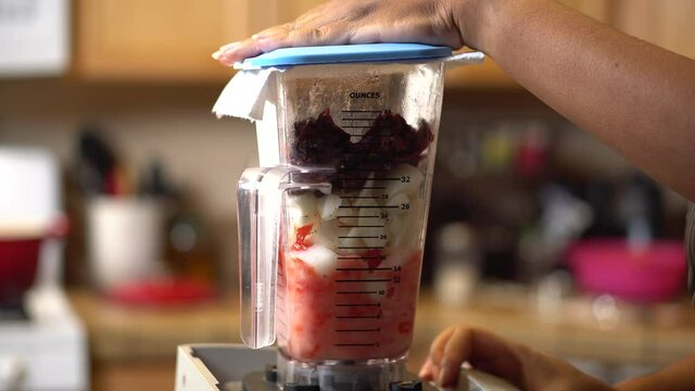 Chopping, mixing and blending onions, tomatoes, and ancho chilies in a blender for a homemade recipe - isolated