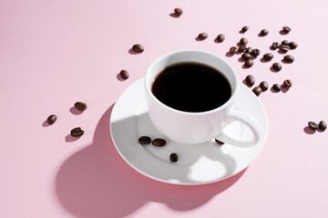  Cup of coffee with beans at pink background