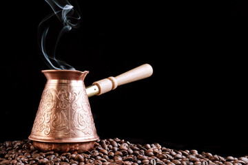 Turkish Jezve Coffee Pot with hot coffee at coffee beans background