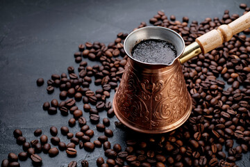 Turkish Jezve Coffee Pot with hot coffee at coffee beans background