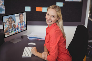 Portrait of happy caucasian female teacher using computer on video call with schoolboy