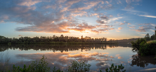 Panoramic Riverside Sunrise with Cloud Reflections
