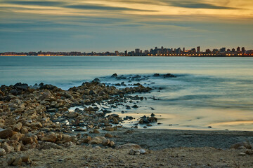 landscape on the beach of warm colors at sunset with a city behind © ares