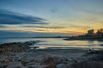 landscape on the beach of warm colors at sunset with a city behind © ares