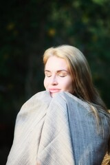 A girl in a blanket in the sunlight emotions of tenderness