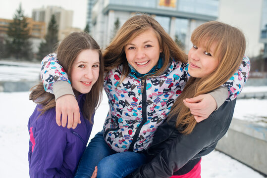 Portrait of smiling friends carrying woman in park