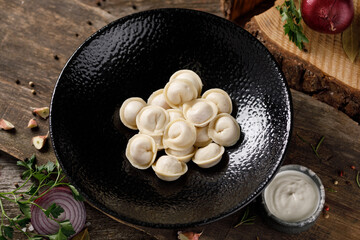 Appetizing traditional Russian dumplings, handmade. Still life on a wooden board. Close-up.