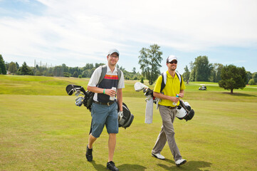 Male friends walking on golf course