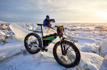 Fototapeta na wymiar Man with bicycle on the frozen lake.